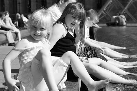 A alegria das meninas brincando na água na fonte do Louvre em Paris